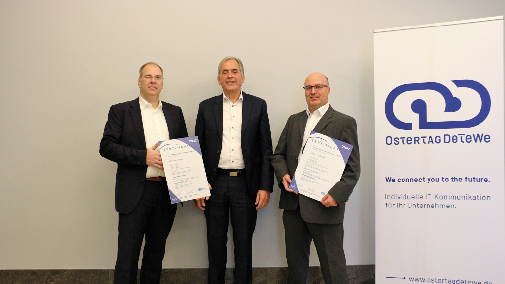 Marcus Leifermann, Director Operations & Management Systeme bei Ostertag DeTeWe und Markus Greuter Umweltmanagementbeauftragter der Ostertag DeTeWe erhalten das ISO 50001 und das ISO 14001 Zertifikat von Hans Kolligs, Hauptgesellschafter bei der Deutsche Managementsystem Zertifizierungsgesellschaft (DMSZ) GmbH, überreicht.